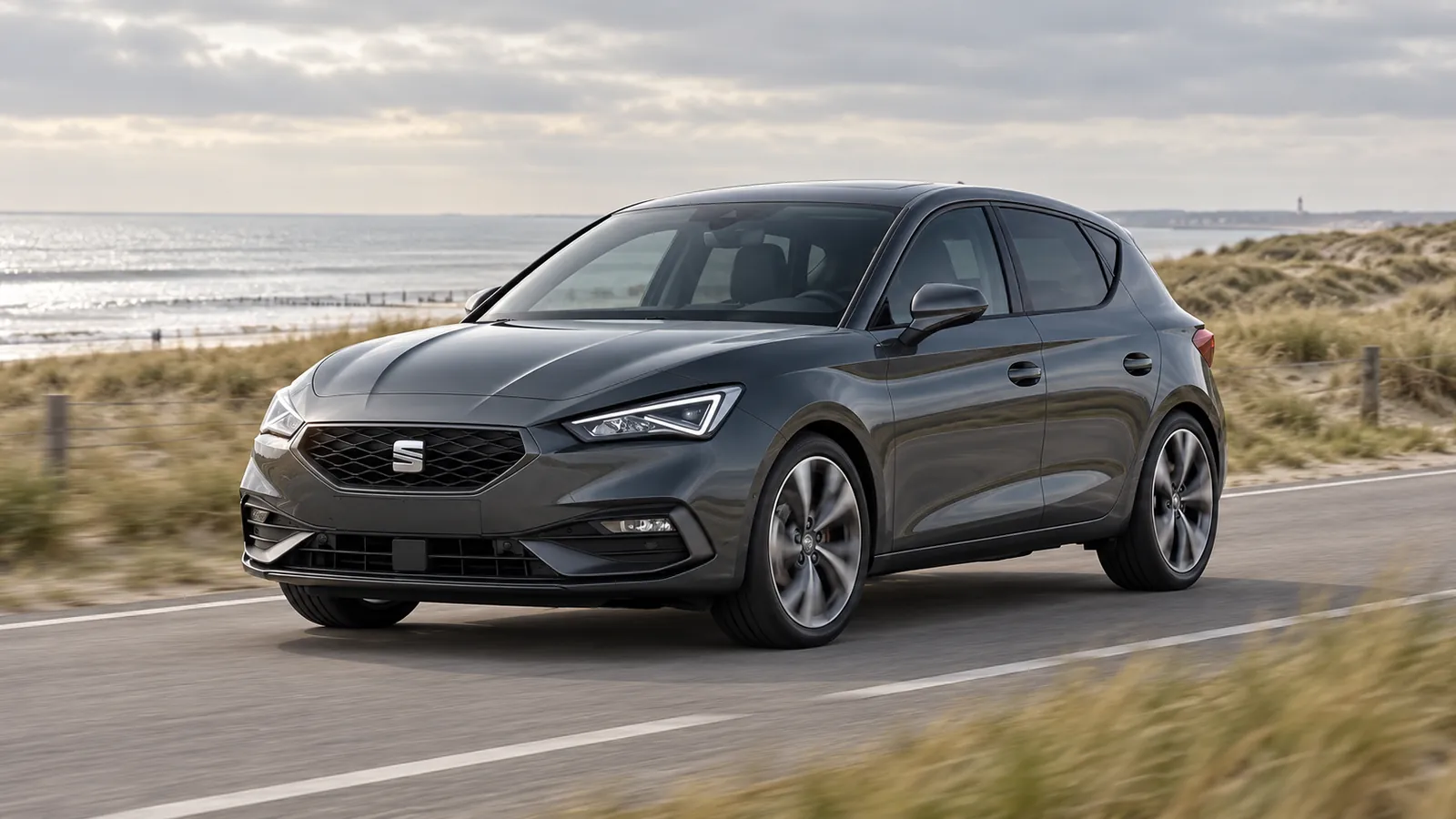 Grauer SEAT Leon auf einer Küstenstraße.